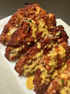 three pieces of fried chicken covered in cheese