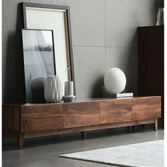 a wooden entertainment center with two vases and a framed photograph on it's shelf