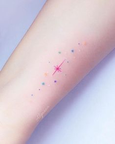 a person with a tattoo on their arm that has stars and an arrow drawn on it