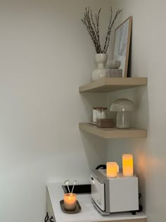 two shelves with candles on top of them