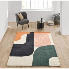 a living room with white walls and wooden floors, an area rug that has various colored squares on it