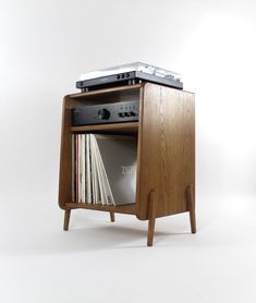 an old record player is sitting on top of a wooden stand with records in it