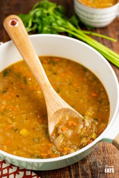 a white bowl filled with soup and a wooden spoon