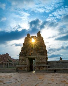 the sun shines brightly through the clouds above an ancient temple