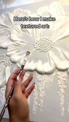 someone is painting a flower on the wall with white paint and text that reads, here's how i make textured art