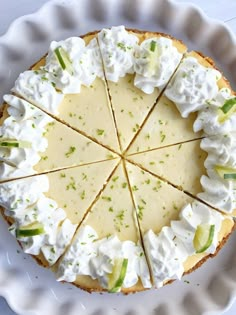 a white plate topped with a cheesecake covered in whipped cream and green onion slices