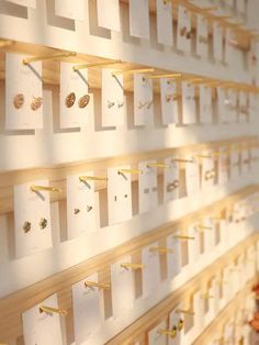 the wall is covered with many different types of jewelry on display, including earrings and necklaces