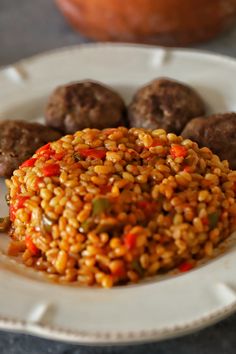 a white plate topped with meatballs and rice