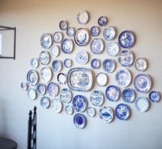 the wall is full of blue and white plates