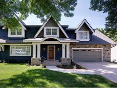 a blue house with white trim on the front and side windows is pictured in this image