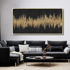 a living room filled with black couches and a painting on the wall above it