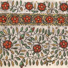 an embroidered cloth with red flowers and green leaves on white fabric, which has gold trim around the edges