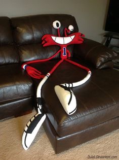 a stuffed animal sitting on top of a brown couch