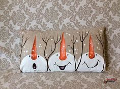 three snowmen with orange hats on their heads are sitting in front of a wall