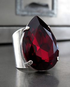 "Dripping in deep blood red, this teardrop crystal ring is a gothic dream! This super-sultry-sexy, so-dark-red-it's-almost-black crystal ring is a whole wicked mood--perfect for your goth Halloween. The oversized, dark red teardrop crystal is perched on a modern & minimalist bezel on a comfortable, wide cuff adjustable ring band (adjusts to fit sizes approx 6 to 10). Select from your choice of antiqued silver plate or glossy gunmetal black adjustable ring band. - Phenomenal deep red teardrop Red Crystal Ring, Black Crystal Ring, Goth Halloween, Swarovski Crystal Rings, Dark Blood, Ruby Crystal, Rainbow Crystal, Blood Red, True Red