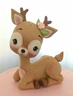 a little deer figurine sitting on top of a pink cake