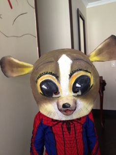 a close up of a stuffed animal wearing a red and blue shirt with black eyes