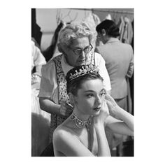 an old photo of a woman getting her tiara put on by a man with glasses