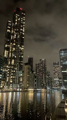 the city is lit up at night by the water