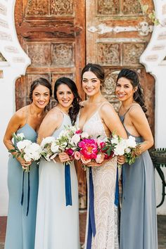 the bride and her bridesmaids pose for a photo in front of an old door