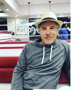 a man wearing a hat sitting on a bench