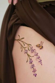 a woman's stomach with flowers and a bee on it