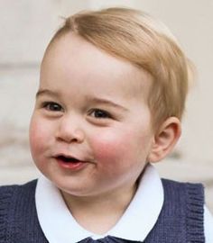 a little boy that is wearing a vest and smiling at the camera while standing in front of some stairs