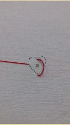 someone is drawing a heart with a needle