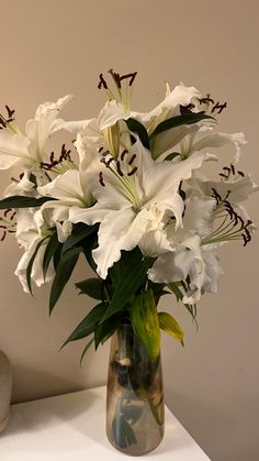 a vase filled with white flowers on top of a table