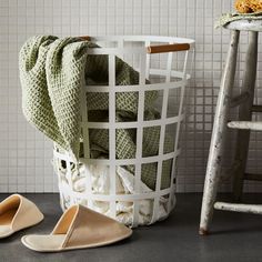 a pair of slippers sitting next to a laundry basket