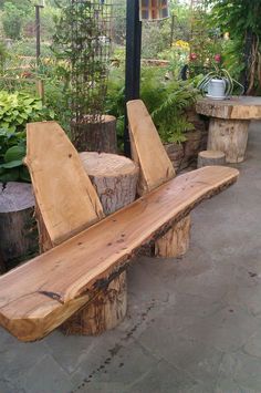 a wooden bench made out of logs in a garden