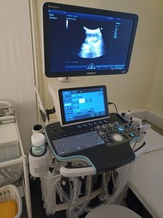 a laptop computer sitting on top of a table in front of a monitor and other medical equipment