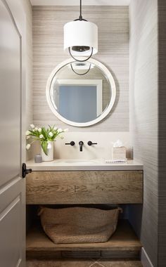 a bathroom sink with a mirror above it and a vase on the counter next to it