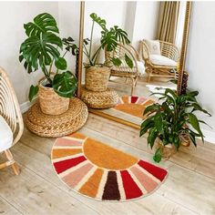 a living room filled with lots of furniture and plants on top of a wooden floor