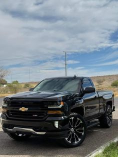 a black truck is parked on the side of the road