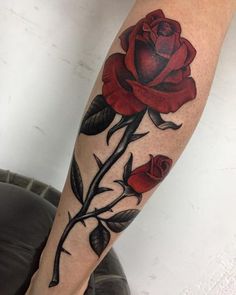 a red rose tattoo on the right arm and leg, with two leaves coming out of it