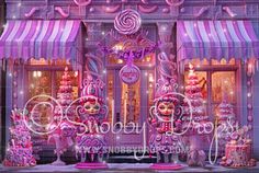 a window display with pink and purple decorations in front of a storefront at night