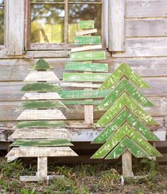 three wooden christmas trees sitting in front of a window