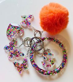 an orange pom - pom sitting on top of a table next to some charms