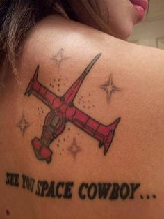 a woman with a tattoo on her back saying see not space cowboy