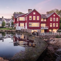 a large red house sitting next to a body of water