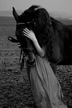 a woman is hugging a horse in the middle of a field with a quote on it