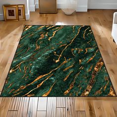 a green rug with gold foiling on it in the middle of a wooden floor