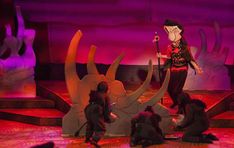 a group of people standing on top of a stage next to giant fake hands holding microphones