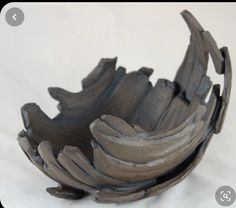 a wooden bowl sitting on top of a white table