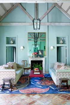 a living room filled with furniture and a fire place in the middle of a room