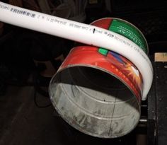 a white hose is connected to a red and green fire extinguisher's bucket