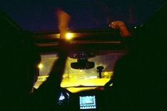 two people in the back seat of a car at night with their cell phones up