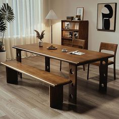 a wooden table with two benches in front of it and a potted plant on the side