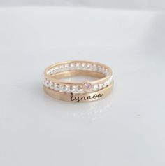 Mother's Day Gift | -the Isabelle- Personalized stackable ring set, engraved with a name, date, or special word.  Metal: .925 sterling silver, and 14k gold filled Dimensions: name ring is 2mm tall on average, but our rings are handmade so variations will occur. Birthstone is 2mm on a 1mm band. Font: lowercase typewriter Unsure what size you need? We highly recommend using our ring sizer for an accurate fit. Some people find that sizing up when stacking 3 or more rings is more comfortable. https: Adjustable White Engraved Ring For Promise, Adjustable White Jewelry With Engraving Option, Adjustable Stackable Engraved Ring For Anniversary, Custom Name White Rings For Anniversary, Personalized White Stackable Rings For Anniversary, Adjustable Engraved Round Ring With Birthstone, Custom Name White Promise Ring, Adjustable Promise Ring With Name, Adjustable Engraved Rose Gold Ring For Anniversary